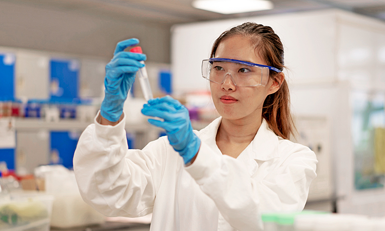 Student observing a test tube in a lab