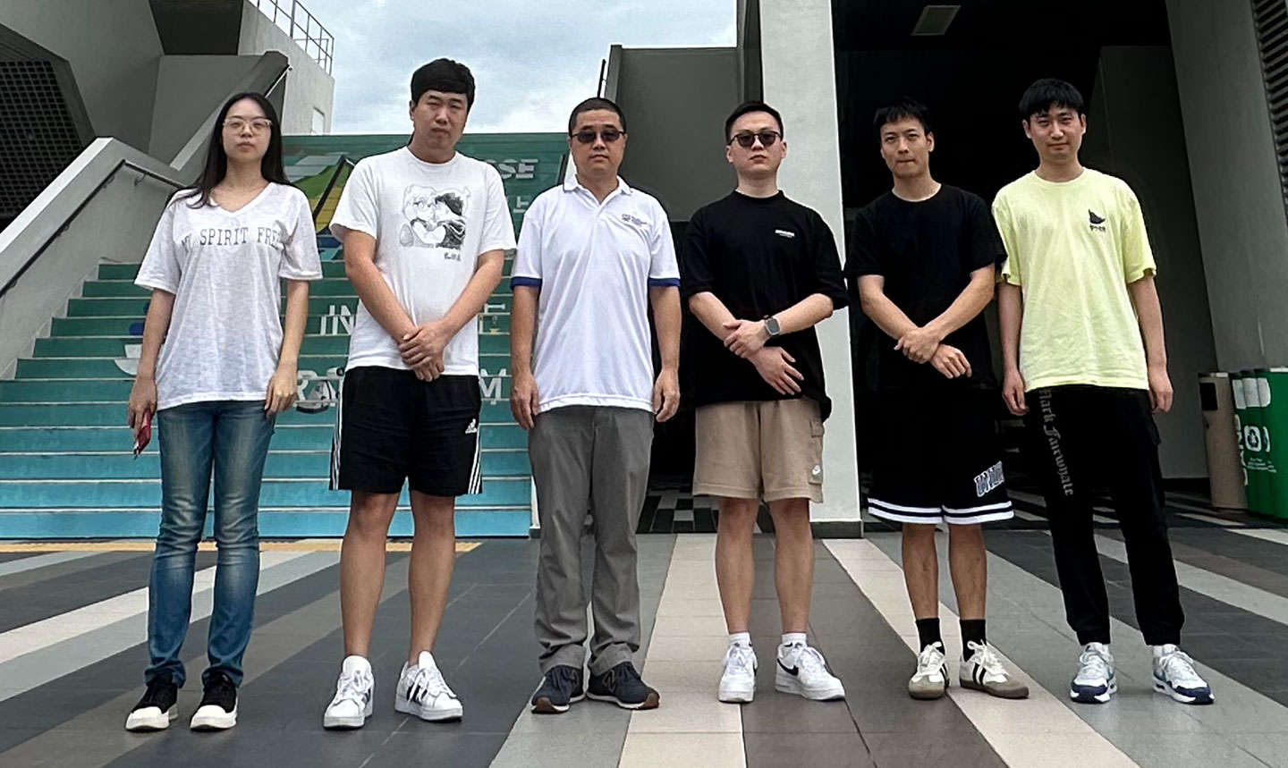 Photo of a group of researchers at the entrance of a college.