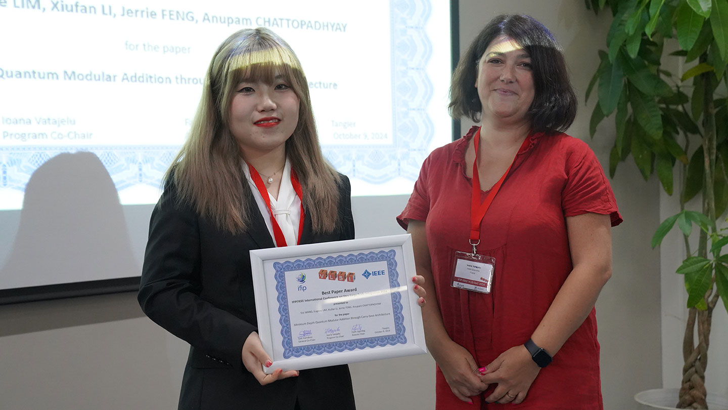 Photo of a female PhD student holding an awarded certificate with a lady standing beside her.