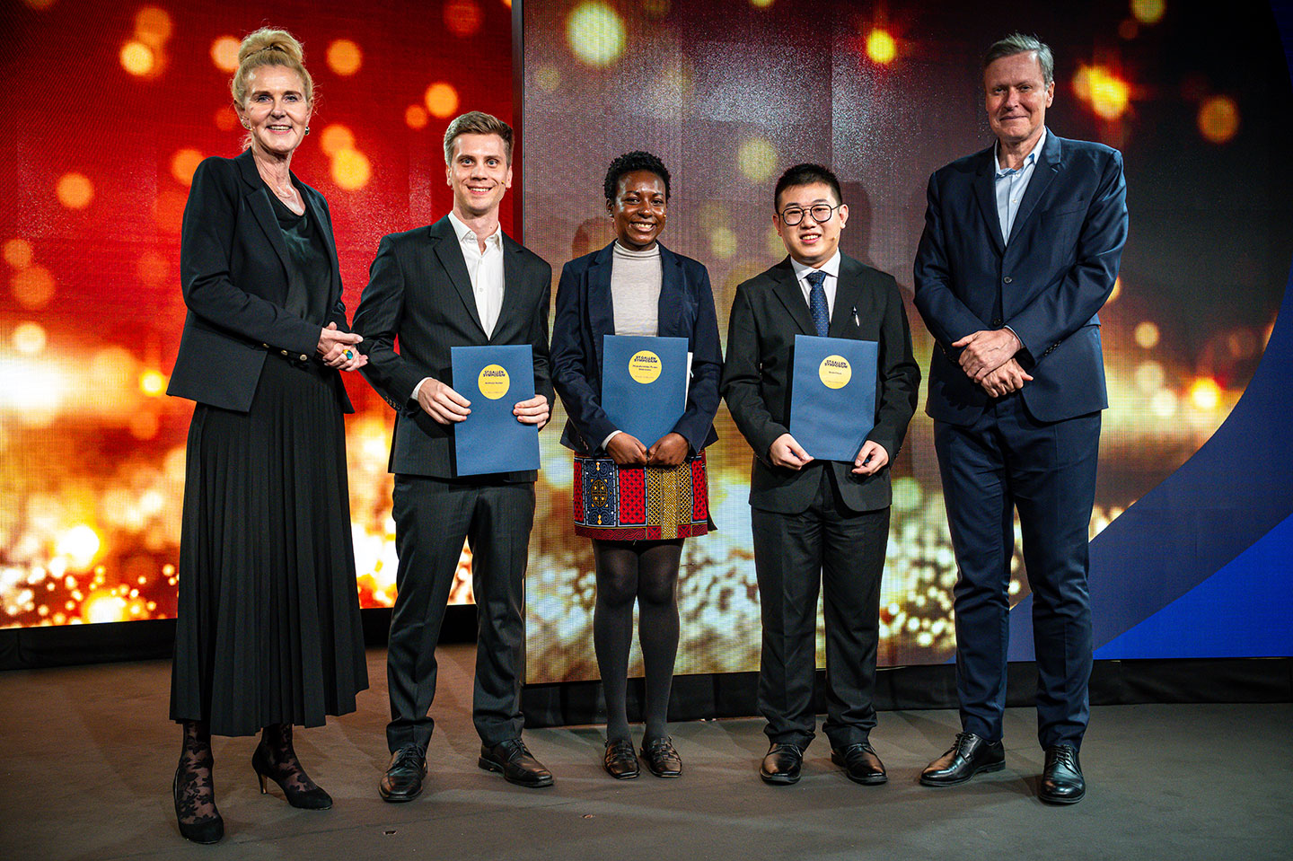 Photo of the three award winners together with two Juries by the side at the 53rd St. Gallen Symposium 2024.
