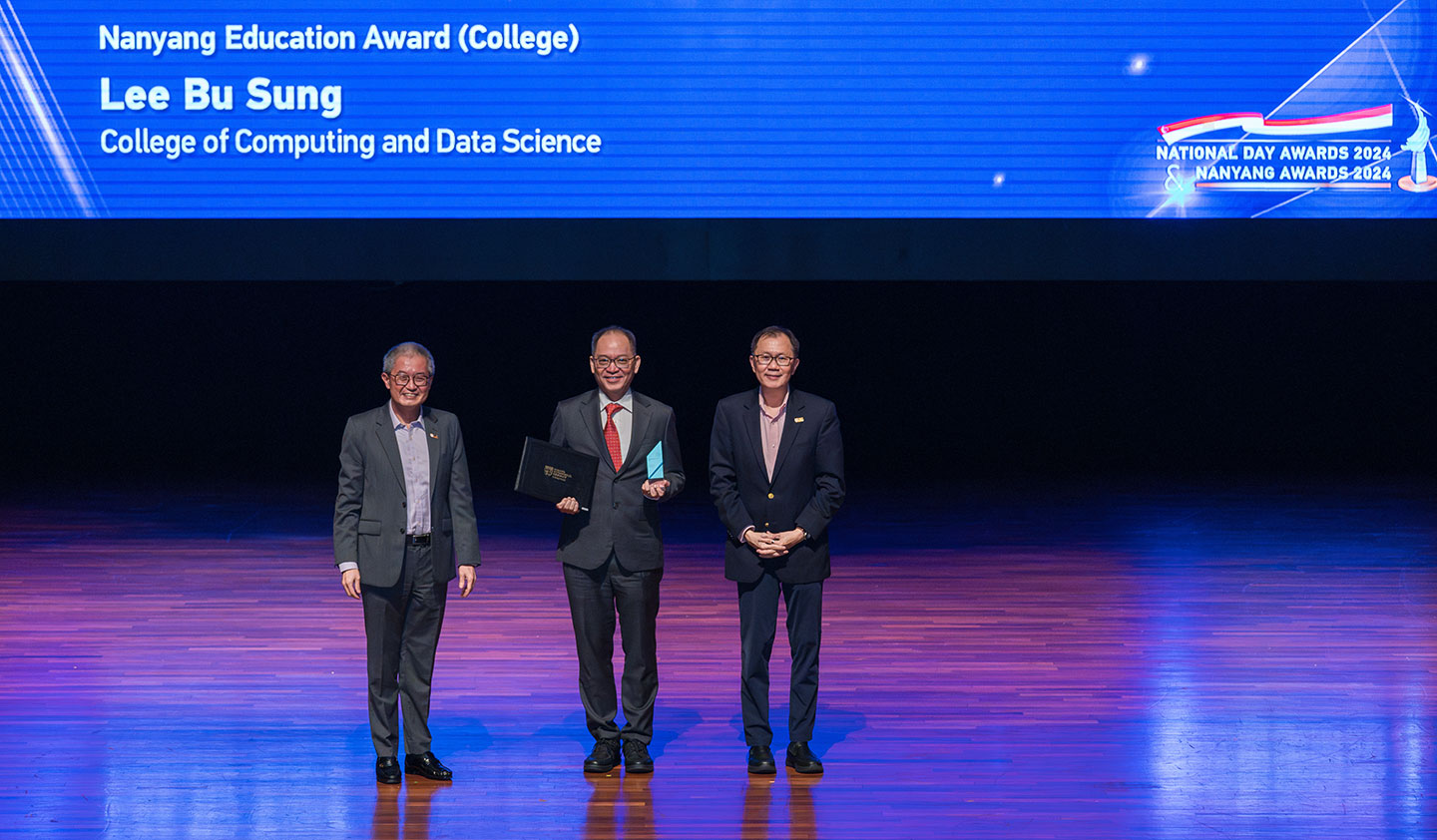 Photo of Prof Lee Bu-Sung receiving the Nanyang Education Award on stage.