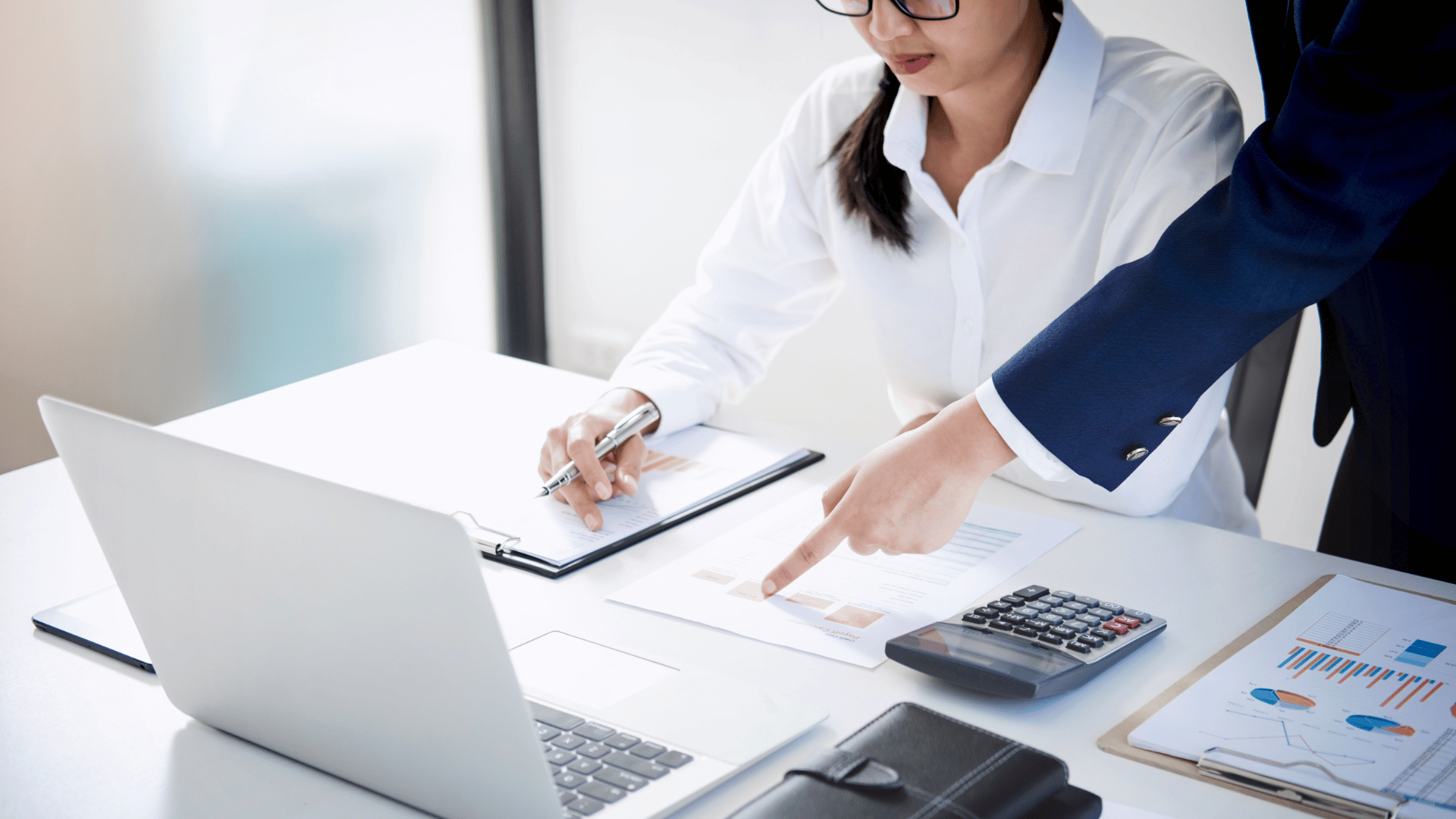 Supervisor instructing employee on a financial report