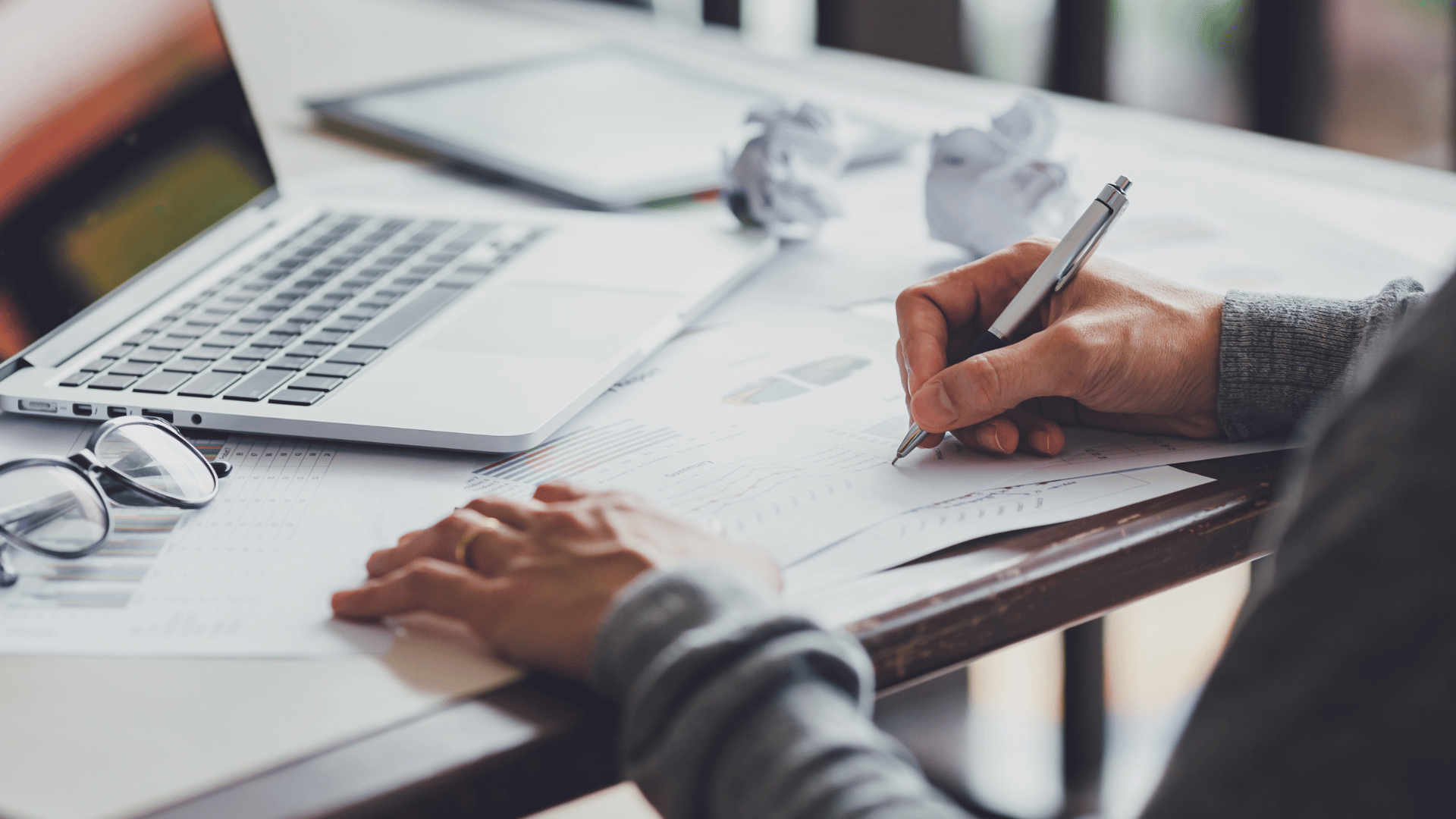 A person writing down accounting data on a piece of paper