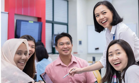 Smiling and Laughing Group of 4 Adults, Classroom with a Young Female Teacher in White Shirt Bob Hair (480x288px)